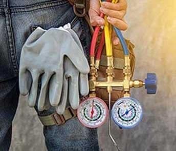 Professional AC Repair Preparation Technician with gauges and gloves servicing HVAC system