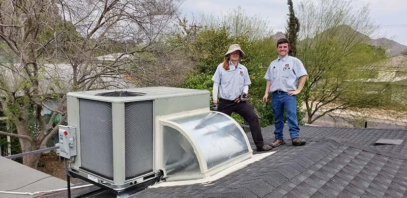 Sean Gresin and Alex by new AC and gas heat unit on home roof, after extensive duct work